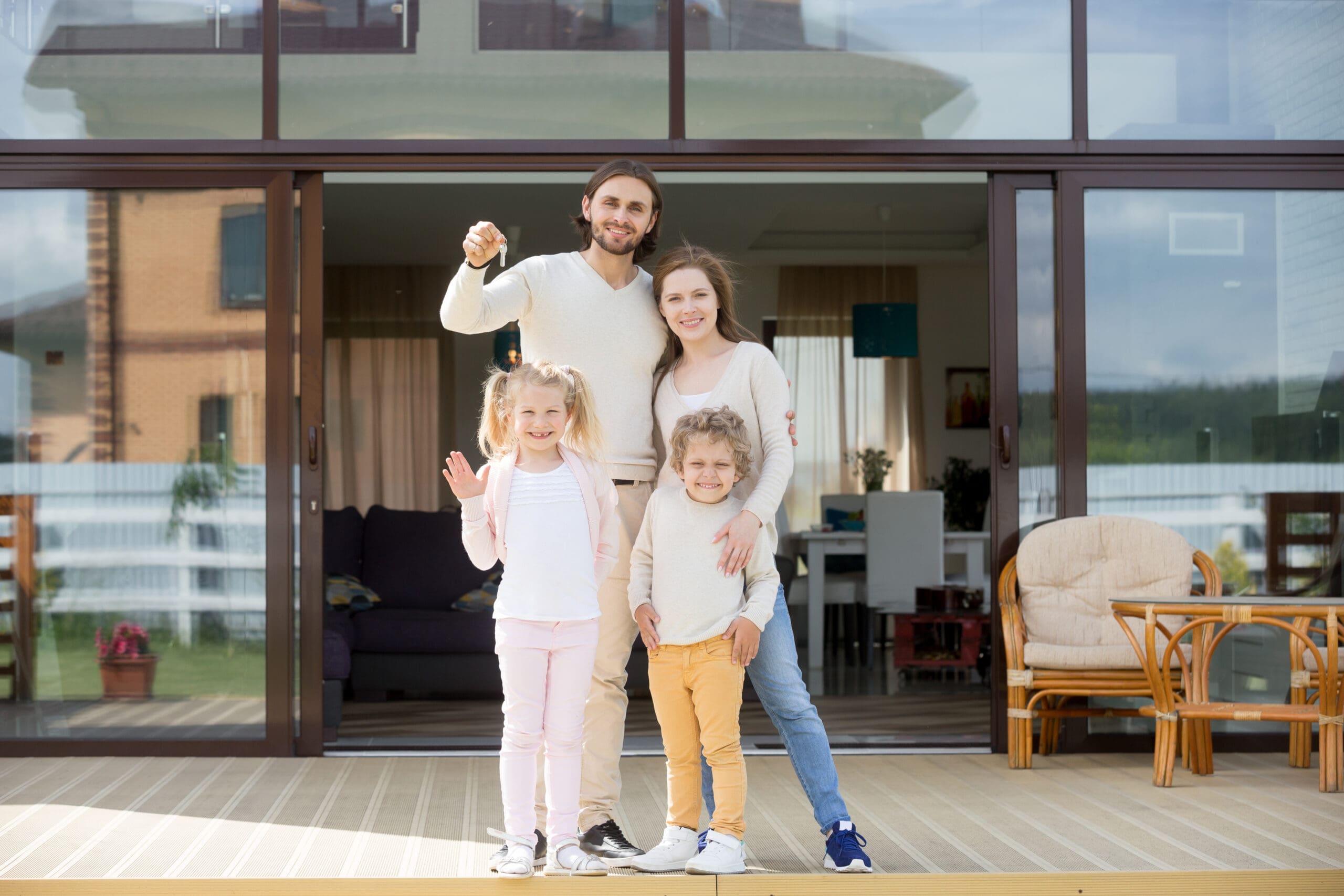 Family with children holding keys looking at camera, buying house Family with children holding keys looking at camera, buying house