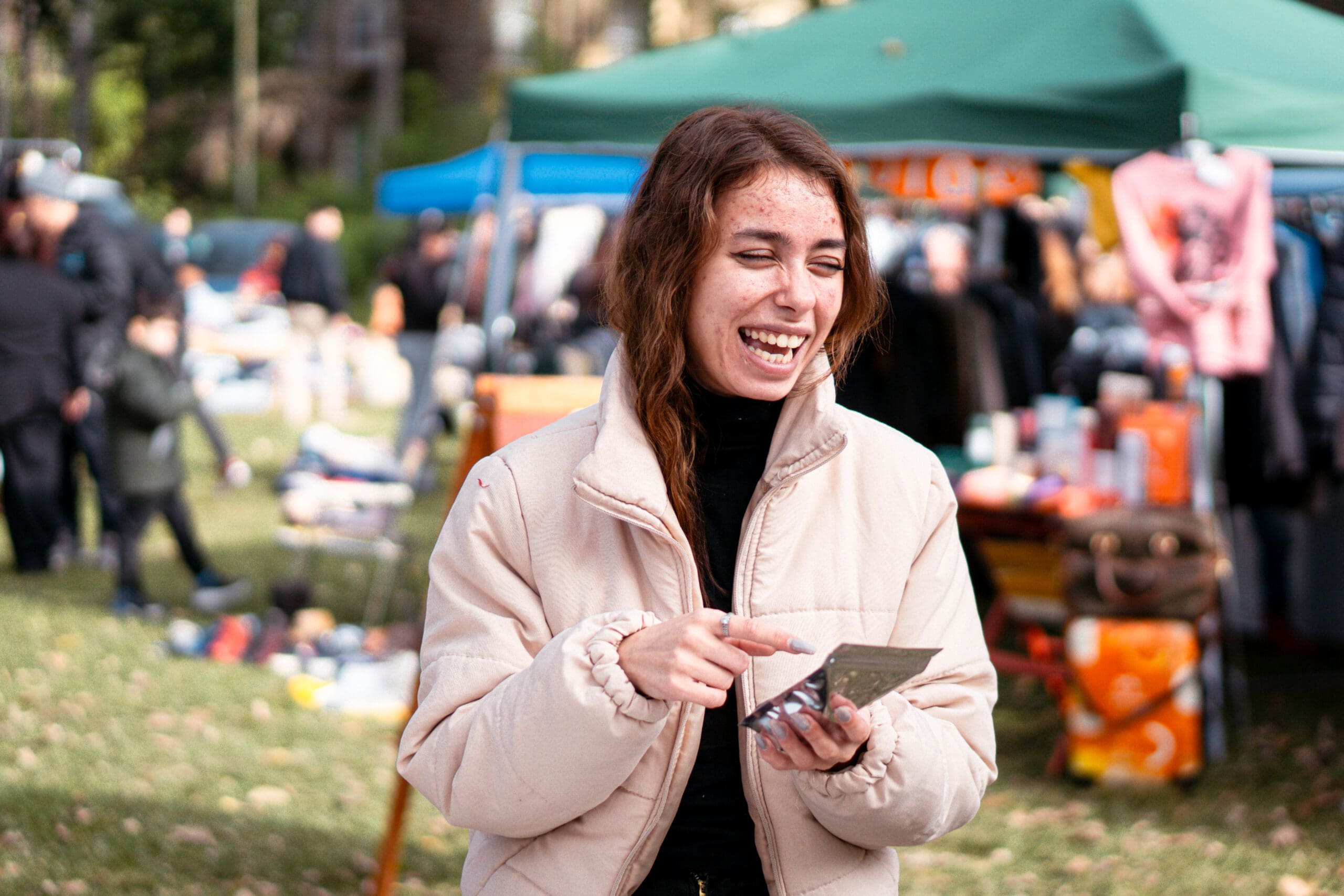 Cheerful woman using contactless payment at outdoor flea market Cheerful woman using contactless payment at outdoor flea market